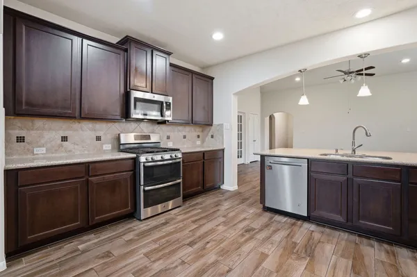 a kitchen with stainless steel appliances granite countertop wooden cabinets a sink and dishwasher