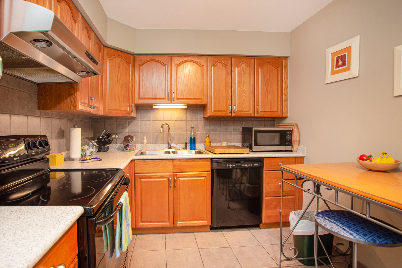 6007 North Sheridan Road, Unit 39D Chicago, IL 60660 - Photo 8 of 20 a kitchen with stainless steel appliances granite countertop a sink stove refrigerator and cabinets