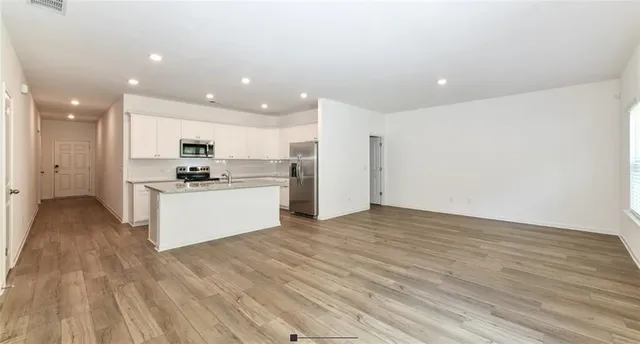 a view of kitchen with refrigerator stove and wooden floor