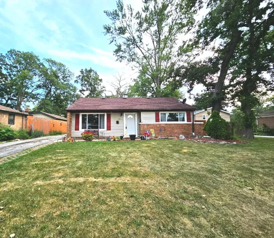 a view of a house with a big yard and large trees