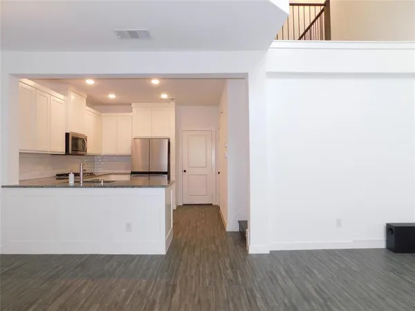 a kitchen with stainless steel appliances a refrigerator and a stove top oven