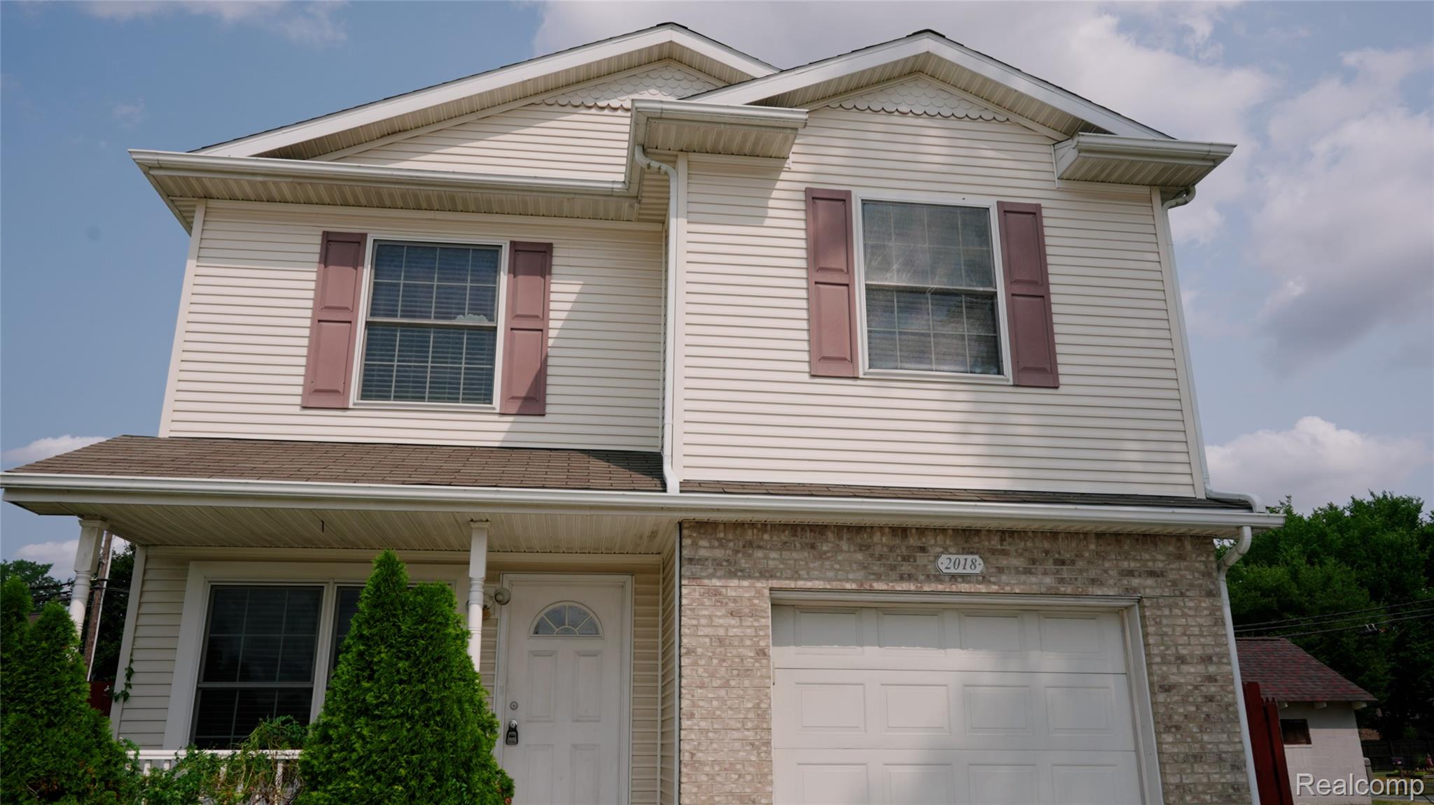 2018 John R Road Troy, MI 48083 - Photo 52 of 57 Two-story residence featuring light-colored siding, a white garage door, and brick facade accents