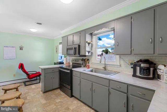 a kitchen with a sink dishwasher and cabinets with wooden floor