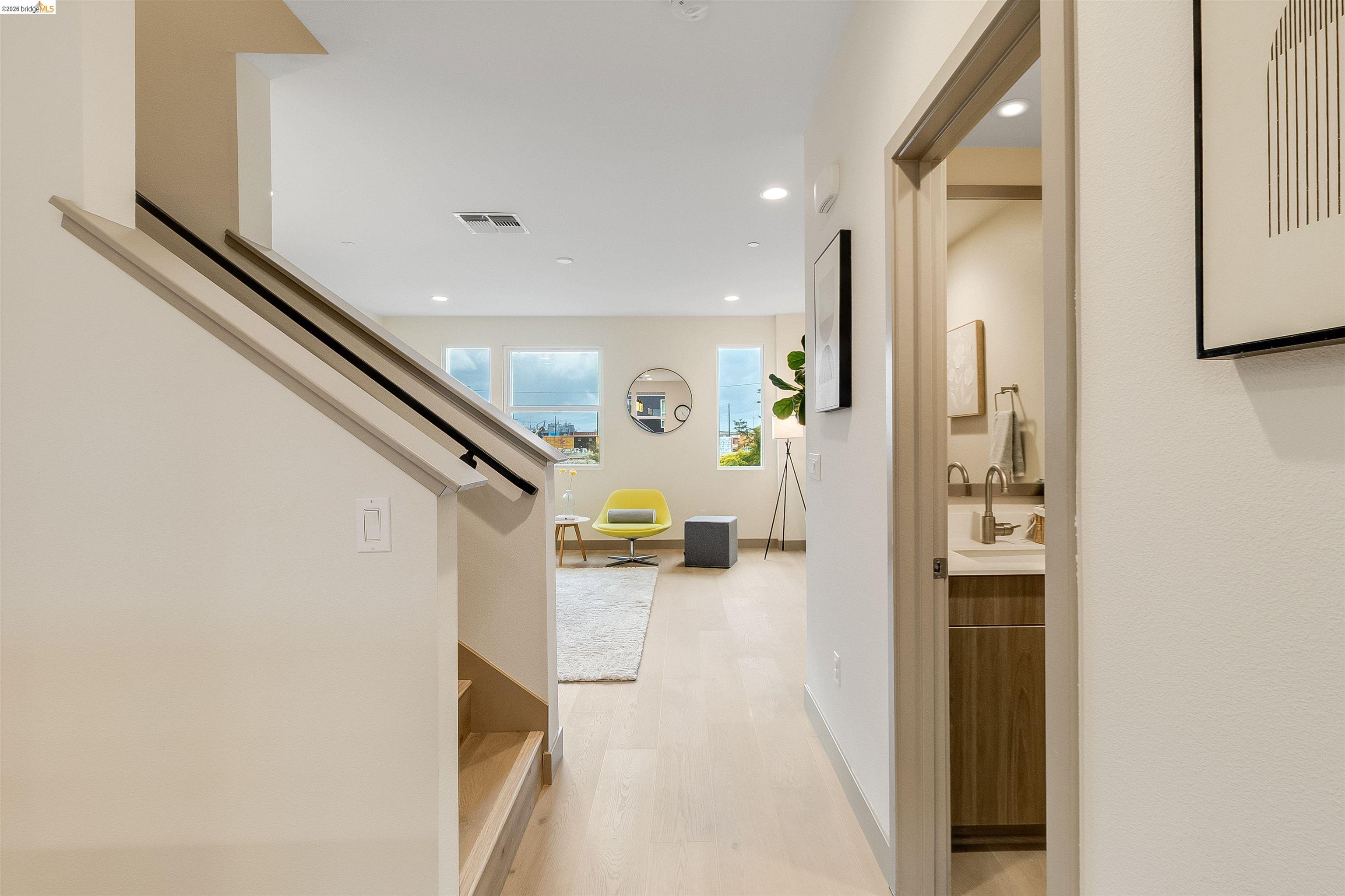 1357 Pullman Way Oakland, CA 94607 - Photo 15 of 37 Open-concept living area with abundant natural light, wood-finish flooring, recessed lighting, and a modern staircase with a black handrail