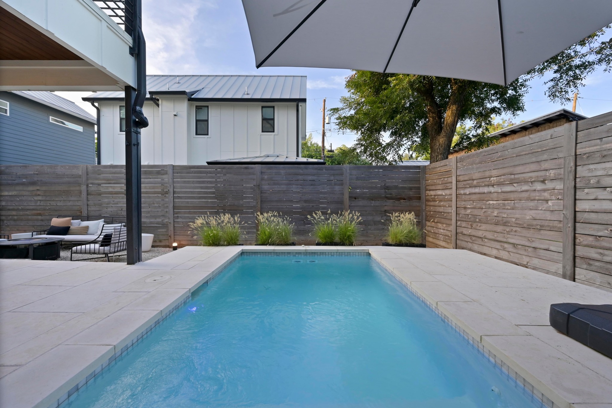 2104 East 2nd Street, Unit 1 Austin, TX 78702 - Photo 31 of 39 a view of a backyard with table and chairs under an umbrella