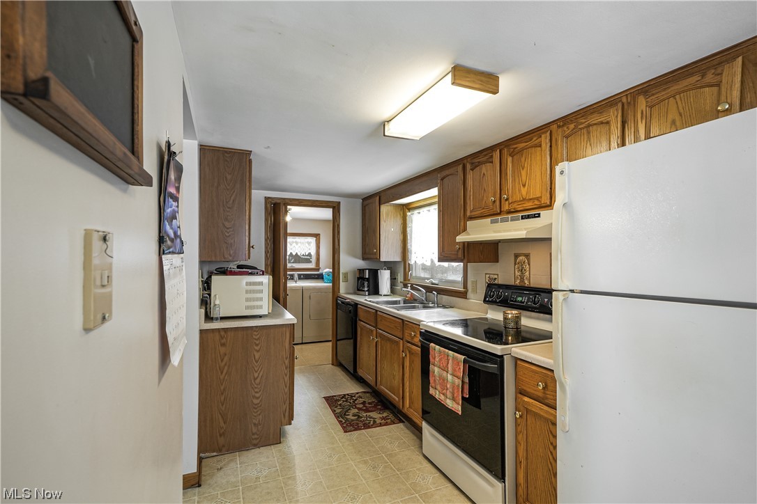 7541 Cooley Road Ravenna, OH 44266 - Photo 13 of 32 Kitchen with white appliances, light tile flooring, and sink