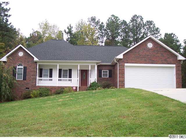 a front view of a house with a yard and trees