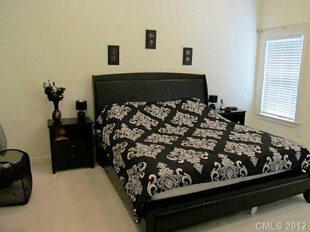 8093 Summit Ridge Drive Catawba, NC 28609 - Photo 11 of 16 a bed sitting in a bedroom next to a window with potted plants