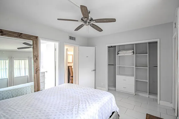 a bedroom with a bed and a ceiling fan