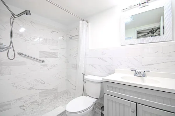 a bathroom with a sink a toilet and shower