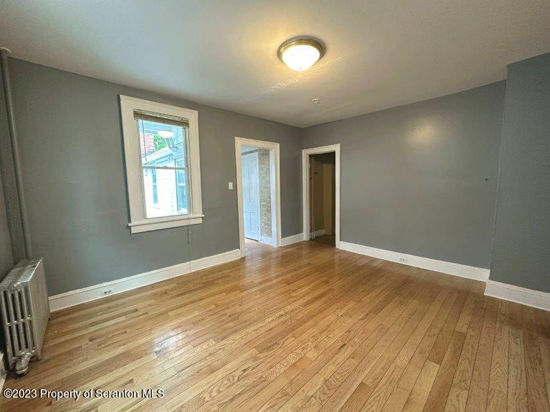 428 Cherry Street Scranton, PA 18505 - Photo 7 of 29 a view of an empty room with wooden floor and a window
