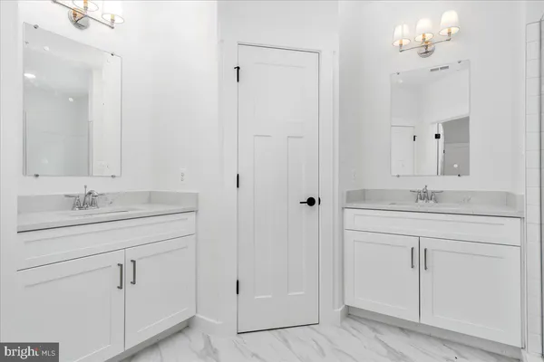 a bathroom with a bathtub a sink a mirror and vanity