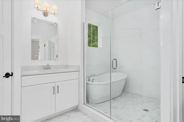 a white bath tub sitting next to a white sink and vanity