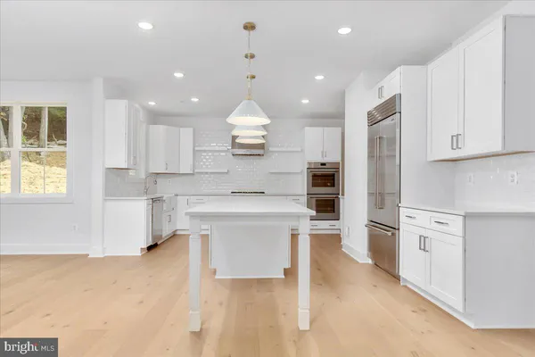 a open kitchen with white cabinets and stainless steel appliances