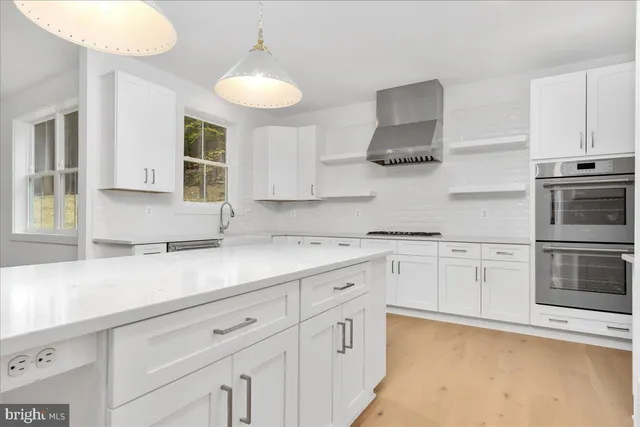a kitchen with granite countertop white cabinets and stainless steel appliances