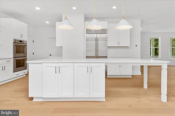 an open kitchen with white cabinets and stainless steel appliances