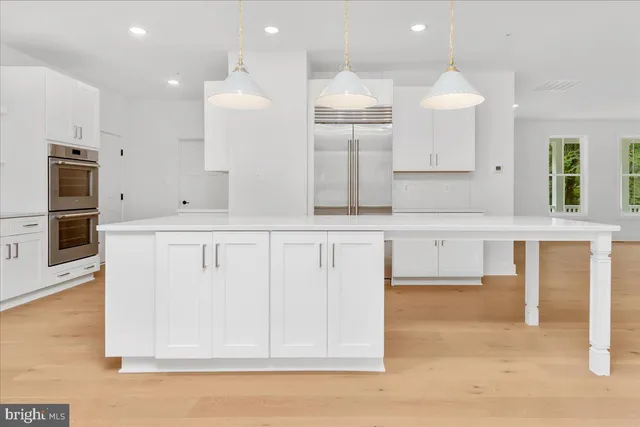 an open kitchen with white cabinets and stainless steel appliances