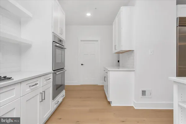a kitchen with white cabinets and white appliances