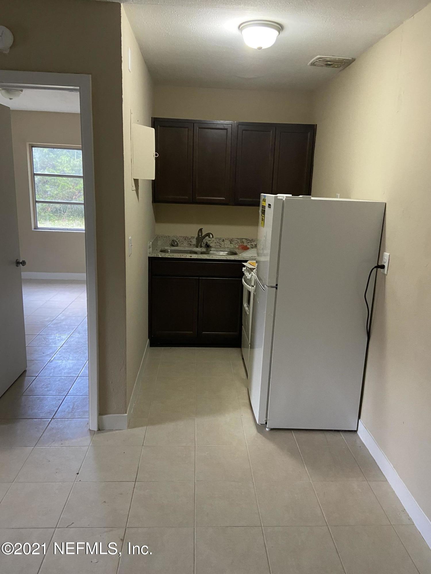 5643 Merrill Road, Unit 4 Jacksonville, FL 32277 - Photo 8 of 9 a kitchen with stainless steel appliances a refrigerator and a stove top oven