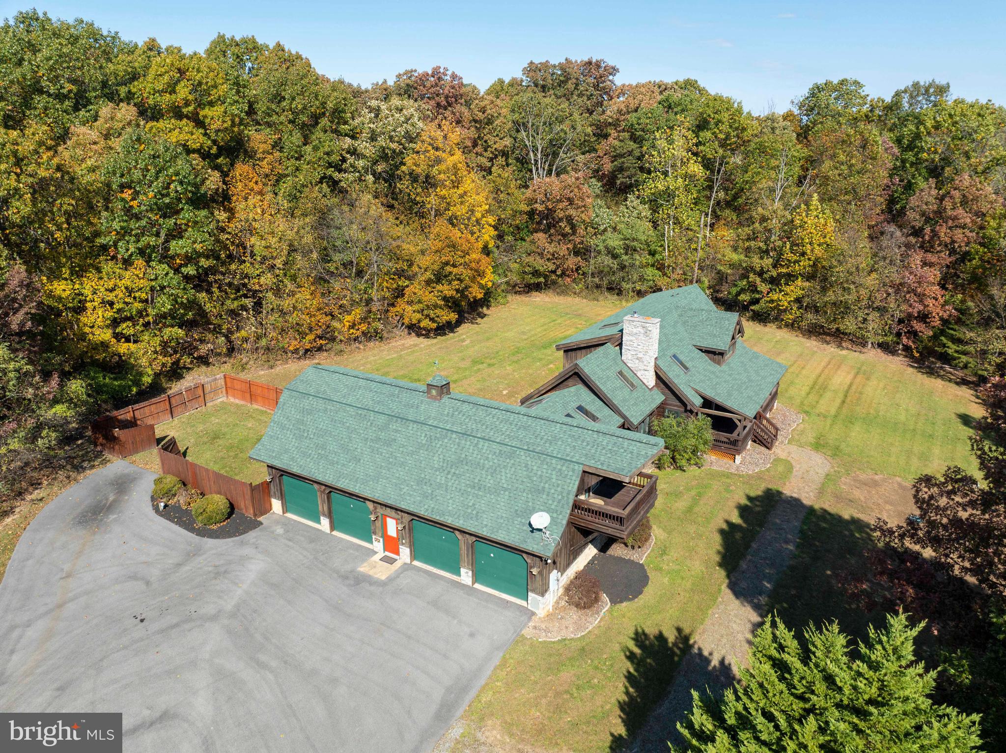 an aerial view of a house with swimming pool and trees