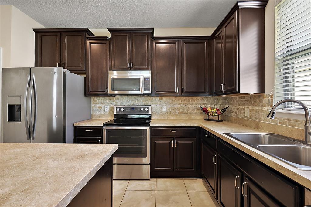 20945 Oldenburg Loop Mount Dora, FL 32757 - Photo 13 of 37 a kitchen with a sink stove and refrigerator