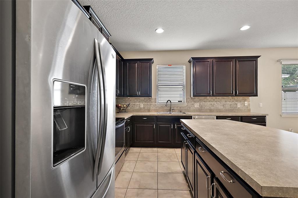 20945 Oldenburg Loop Mount Dora, FL 32757 - Photo 15 of 37 a kitchen with stainless steel appliances granite countertop a refrigerator and a sink