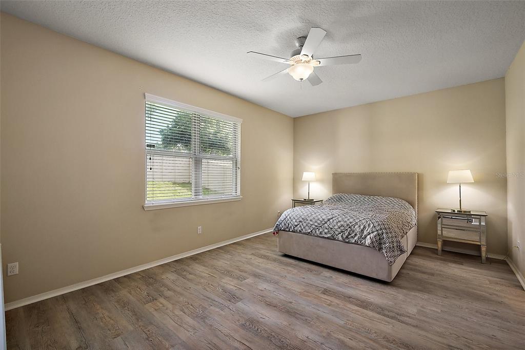 20945 Oldenburg Loop Mount Dora, FL 32757 - Photo 17 of 37 a bedroom with a bed and a chandelier