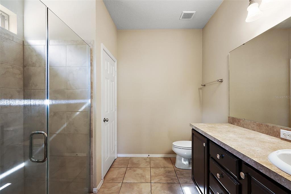 20945 Oldenburg Loop Mount Dora, FL 32757 - Photo 19 of 37 a bathroom with a granite countertop sink a toilet and shower