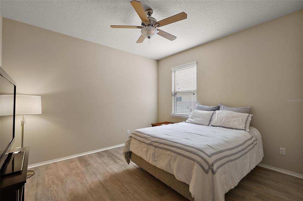 20945 Oldenburg Loop Mount Dora, FL 32757 - Photo 22 of 37 a bedroom with a bed and a ceiling fan