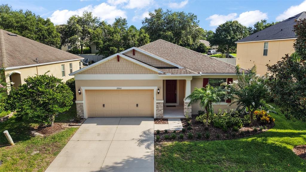 20945 Oldenburg Loop Mount Dora, FL 32757 - Photo 29 of 37 a view of a white house with a yard and large tree