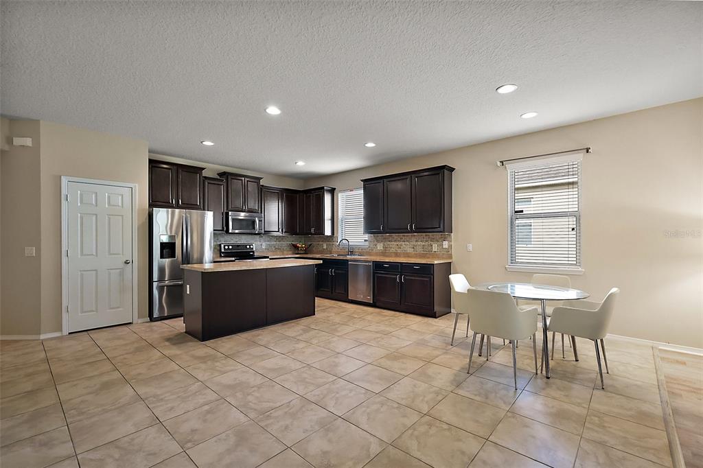 20945 Oldenburg Loop Mount Dora, FL 32757 - Photo 10 of 37 a large kitchen with a large counter top a sink stainless steel appliances and cabinets