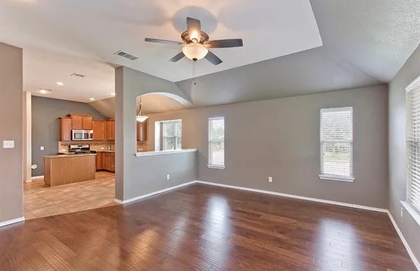 a view of a livingroom with a ceiling fan window and wooden floor