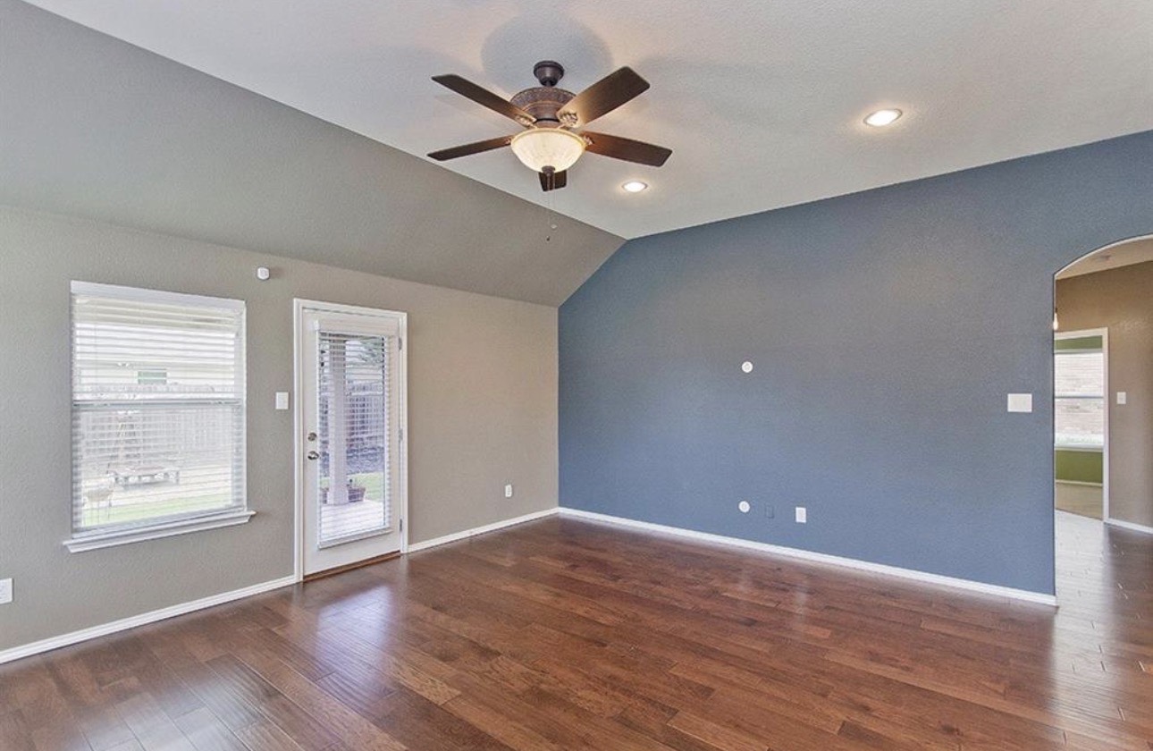 1052 Hot Spring Valley Buda, TX 78610 - Photo 13 of 36 Empty room with arched walkways, plenty of natural light, vaulted ceiling, ceiling fan, and dark wood-type flooring