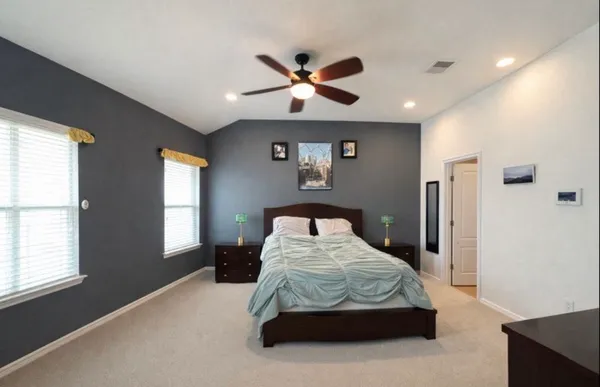 a bedroom with a bed and a large window