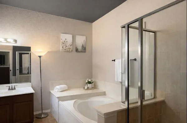 a bathroom with a tub a sink and mirror