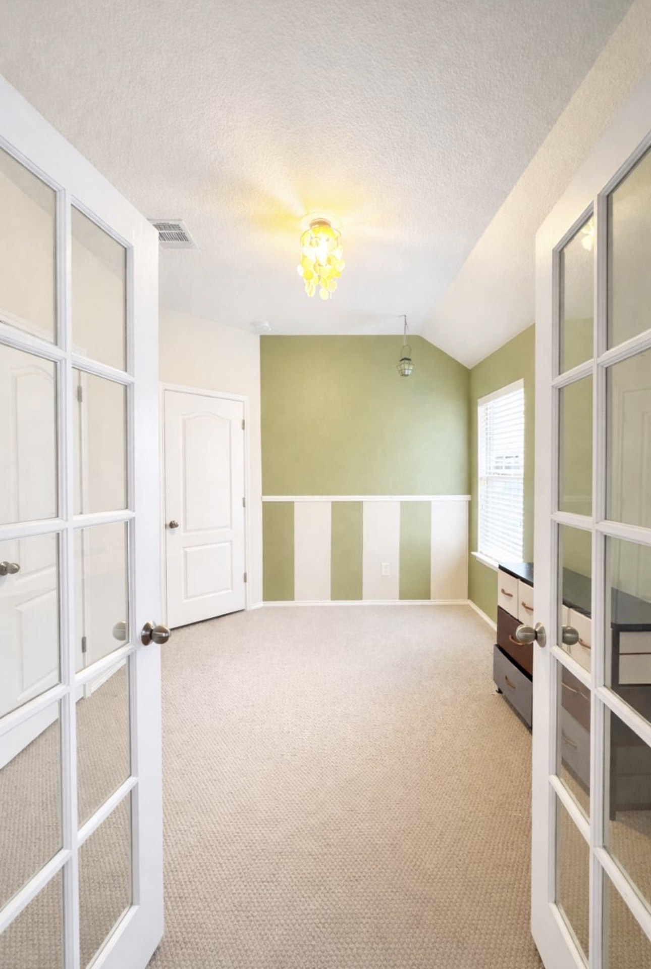 1052 Hot Spring Valley Buda, TX 78610 - Photo 22 of 36 Spare room featuring french doors, lofted ceiling, light carpet, and a textured ceiling