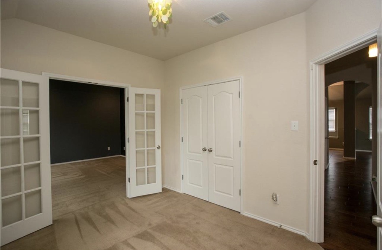 1052 Hot Spring Valley Buda, TX 78610 - Photo 24 of 36 Unfurnished bedroom with french doors, arched walkways, carpet, and a closet