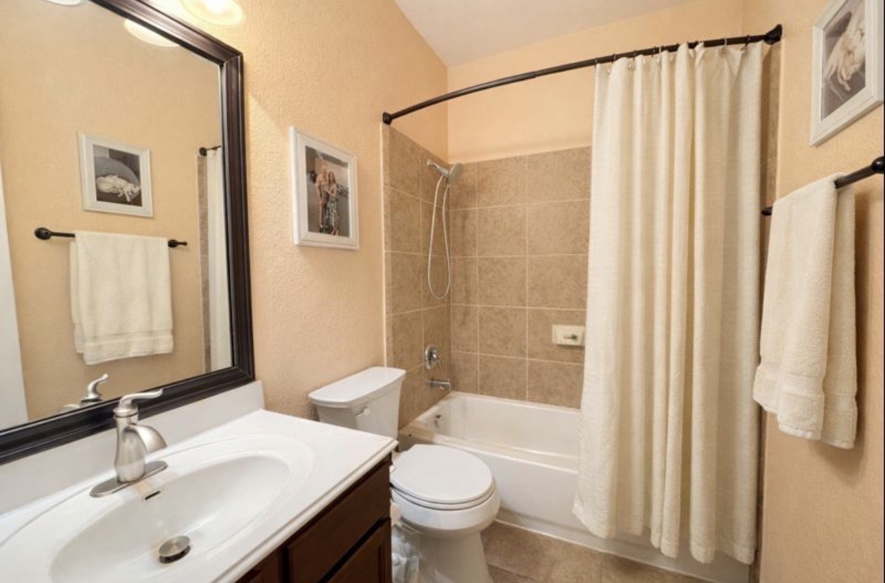 1052 Hot Spring Valley Buda, TX 78610 - Photo 27 of 36 Full bathroom featuring a textured wall, shower / tub combo with curtain, and vanity