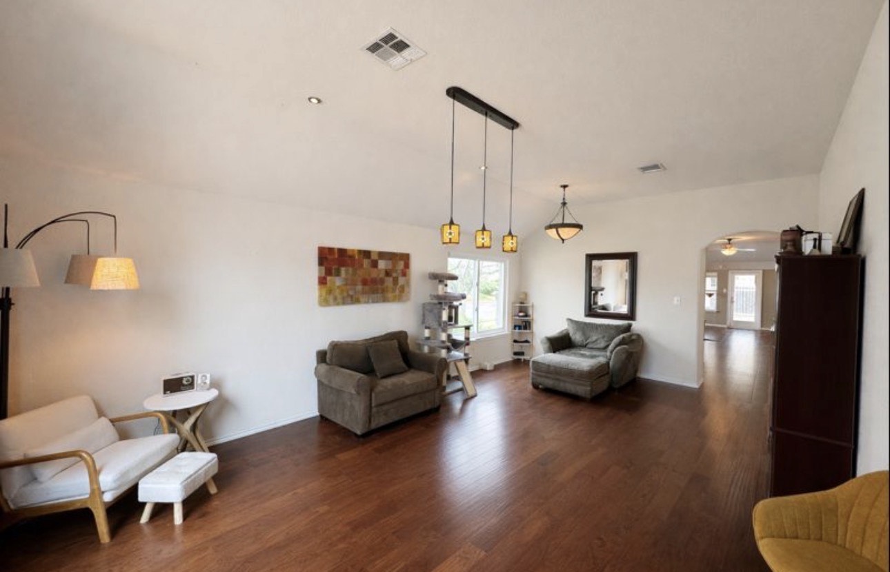 1052 Hot Spring Valley Buda, TX 78610 - Photo 3 of 36 Living room featuring arched walkways, dark wood-style floors, and healthy amount of natural light