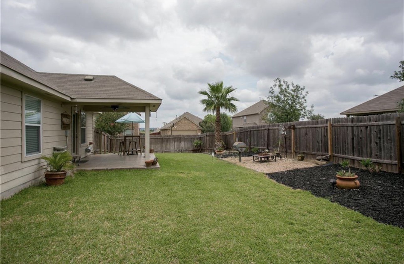 1052 Hot Spring Valley Buda, TX 78610 - Photo 32 of 36 Fenced backyard featuring a patio and a fire pit