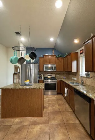 a kitchen with stainless steel appliances granite countertop a sink counter top space and cabinets