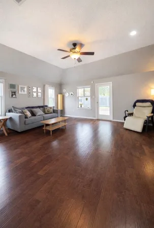 a view of a livingroom with furniture a ceiling fan and window
