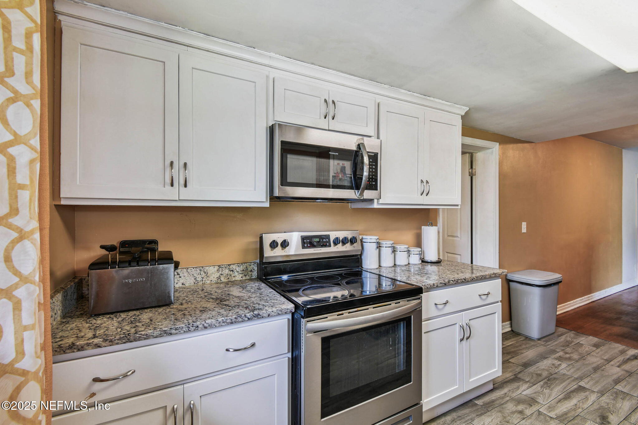 623 Mandalay Road Jacksonville, FL 32216 - Photo 13 of 36 a kitchen with stainless steel appliances granite countertop a stove a microwave and cabinets