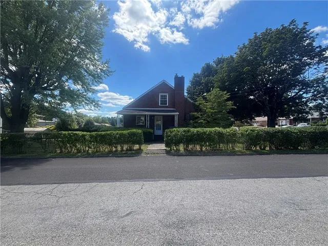 a front view of a house with yard and trees