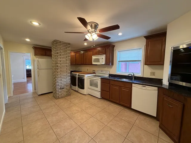 a kitchen with stainless steel appliances granite countertop a stove sink and cabinets