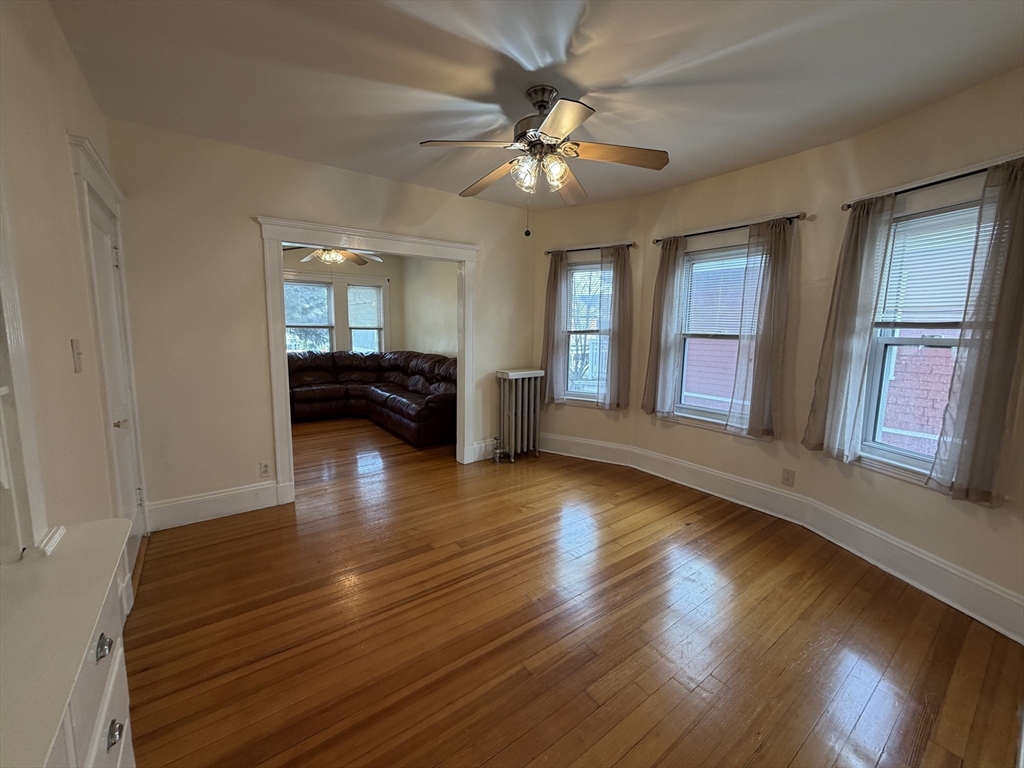 46 Walker Street, Unit 2 Somerville, MA 02144 - Photo 8 of 18 a view of an empty room with wooden floor and a window