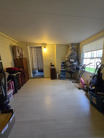 a living room with furniture and a gym machine next to a window