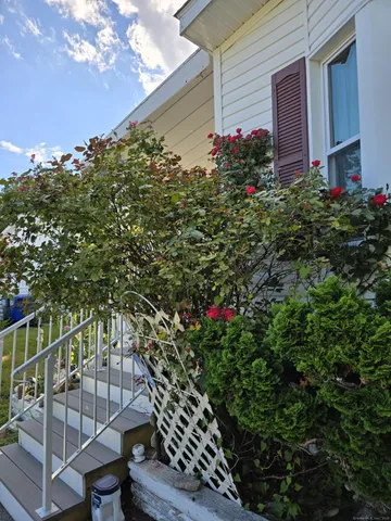 a backyard of a house with flower plants and wooden fence