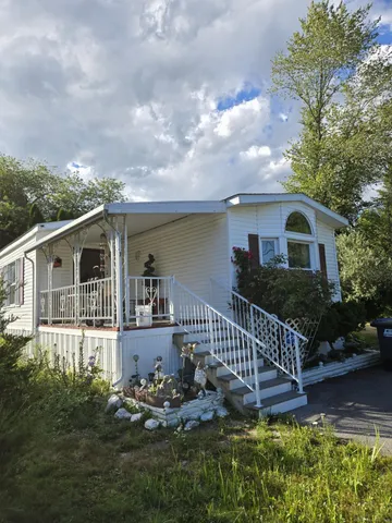 a view of a house with backyard and sitting area