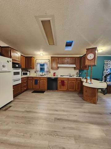a large kitchen with stainless steel appliances granite countertop a stove and a refrigerator